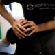 Physiotherapist or chiropractor assessing a patient's knee mobility at Motion Care Clinic